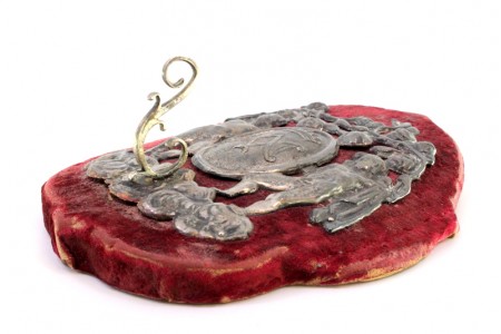 Suporte em prata de parede com base em madeira e revestimento de veludo.