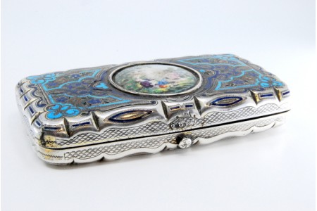 Cigarreira em prata esmaltada na tampa e reverso com volutas gravadas e tampa basculante.