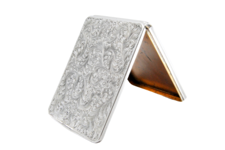 Cartoneira em prata com gravados rameados, tampa basculante e interior dourado.