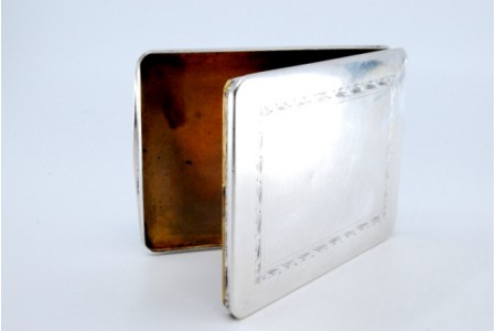 Cartoneira em prata com gravados rameados, tampa basculante e interior dourado.