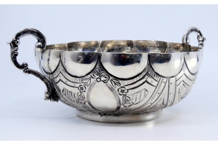 Bomboneira em prata com gravados e concheados com duas asas como pegas.