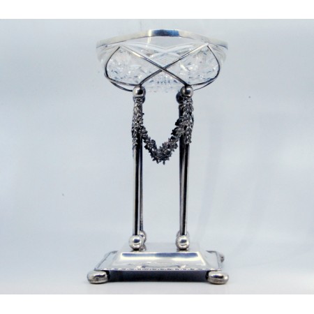 Fruteira em cristal lapidado com estrutura em prata suportado por quatro pilaretes cobertos de flores e assente sobre base lisa com quatro pés em forma de bola