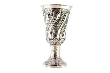Taça em prata com relevos sobre base ondeada em forma circular.