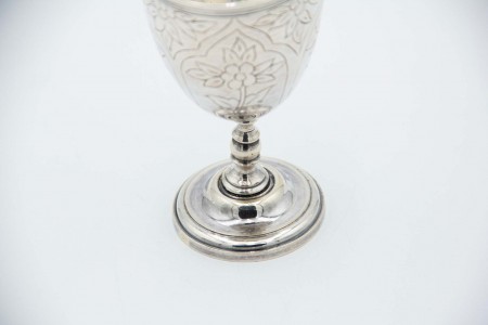 Taça de prata de base circular com motivos florais relevados.