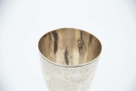 Taça de prata com relevos e motivos florais gravados.