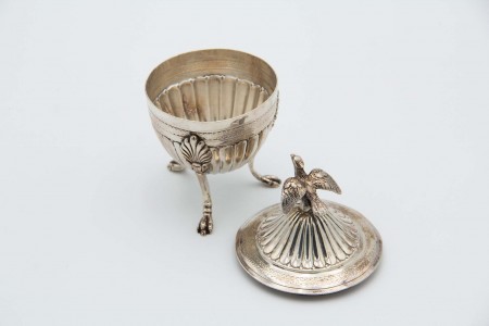 Taça de prata com ave de rapina na tampa e três pés de suporte