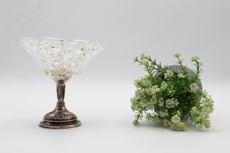 Taça de cristal lapidado com base em prata e motivos florais relevados com enchimento na base.