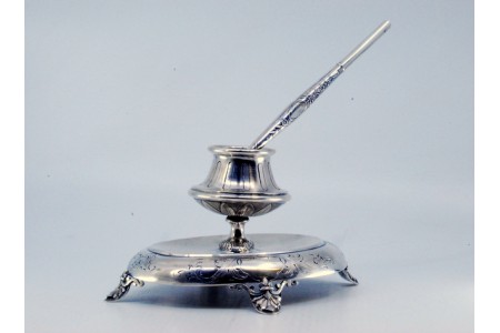  Tinteiro em prata com base cinzelada, quatro pés de apoio e caneta.