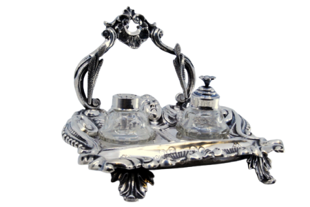 Tinteiro em prata com relevos e aplicações, com dois recipientes em vidro assente em quatro pés com palmas.