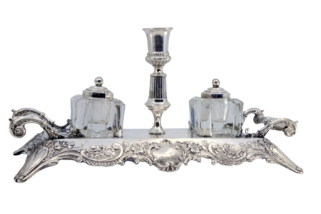 Tinteiro em prata com dois depósitos em vidro lapidado com tampas em prata e duas pegas laterais com relevos.