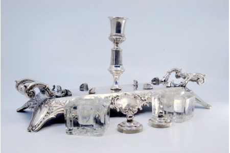 Tinteiro em prata com dois depósitos em vidro lapidado com tampas em prata e duas pegas laterais com relevos.