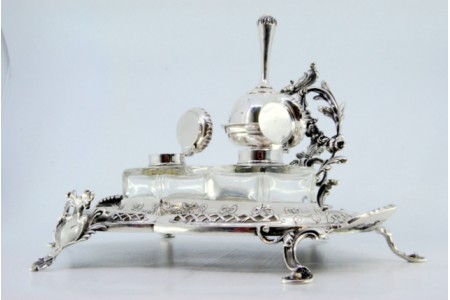  Tinteiro em prata recortada com campainha e dois depósitos em vidro com relevos e aplicações.