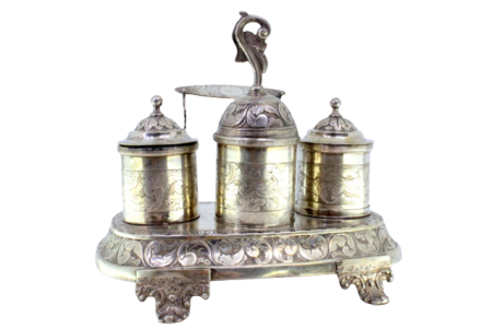 Tinteiro em prata cinzelada com volutas, folhas de acanto, dois depósitos e campainha, suporte para canetas e assente sobre quatro pés relevados sobre friso liso