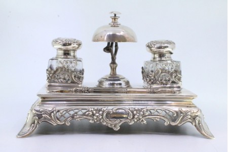 Tinteiro em prata com dois depósitos em vidro, tampas em prata com relevos e caneta.