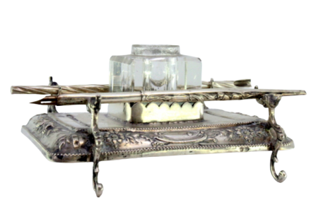 Tinteiro em prata relevado com motivos florais, friso perlado na envolvência, suporte para canetas, depósito em vidro e assente sobre quatro pés em forma de dragões.