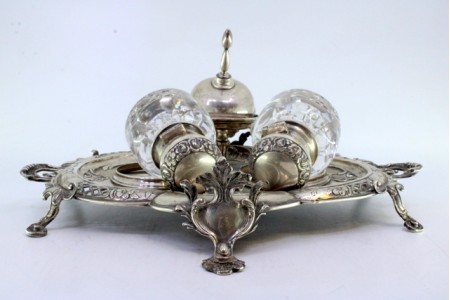 Tinteiro em prata com dois depósitos em vidro com tampas em prata, campainha assente em base recortada com relevos