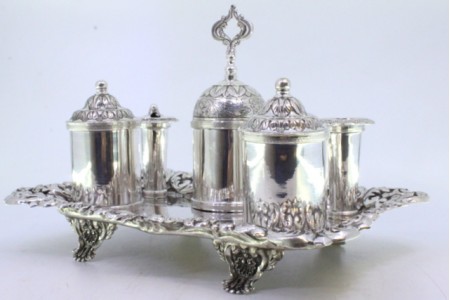  Tinteiro em prata relevada com dois depósitos, campainha, suportes para canetas e assente em quatro pés em forma de garras.