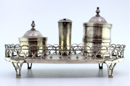 Tinteiro em prata com dois depósitos assente em base com gradinha e quatro pés recortados.