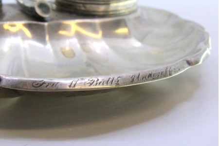 Tinteiro em prata em forma de concha com relevos e aplicações, dois depósitos em vidro e suporte com caneta.