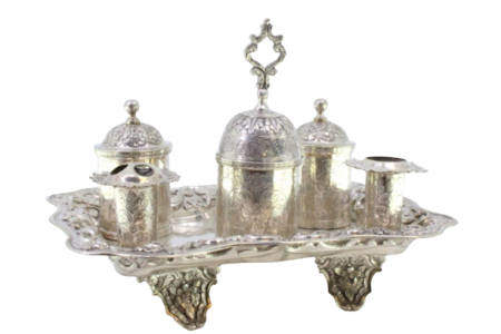 Tinteiro em prata cinzelada dois porta penas, dois depósitos, campainha e assente sobre quatro pés com relevos florais.