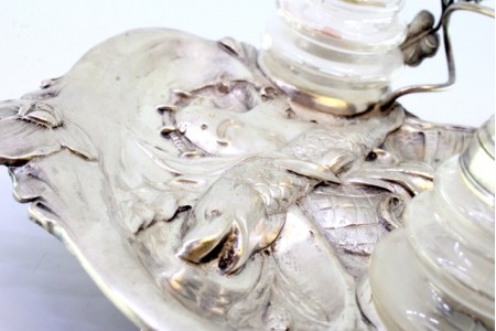 Tinteiro em prata com figura de peixe relevada e folhas de acanto como suporte para caneta com dois depósitos em vidro.