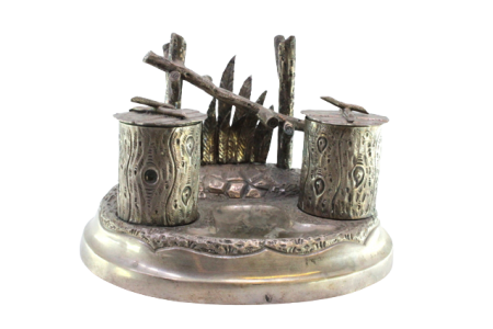 Tinteiro em prata com dois depósitos em forma de troncos, suporte para caneta e base relevada.