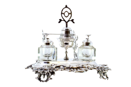 Tinteiro em prata com dois depósitos em vidro facetado,  pomo nas tampas,  campainha,  porta penas, com relevos e base recortada com quatro pés