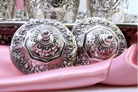 Tinteiro em prata cinzelada com dois depósitos e campainha, base, suportes de canetas e assente em quatro pés vazados.