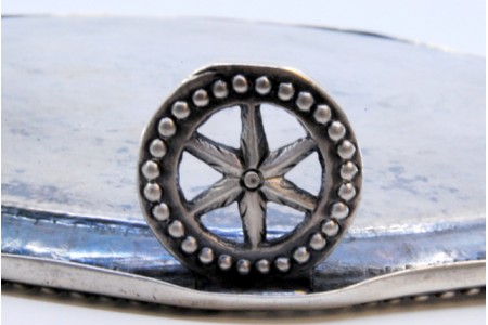 Bandeja em prata com gravados, rebordo perlado e assente sobre três pés em forma de rodas.