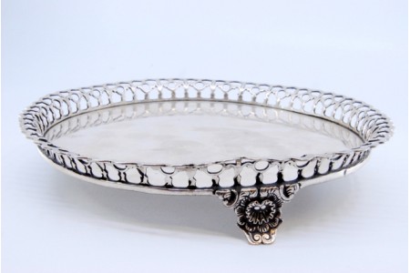 Bandeja/bilheteira em prata com gradinha com o fundo liso e assente sobre três pés relevados.