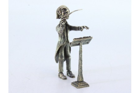 Figura de maestro em prata com batuta e pauta.