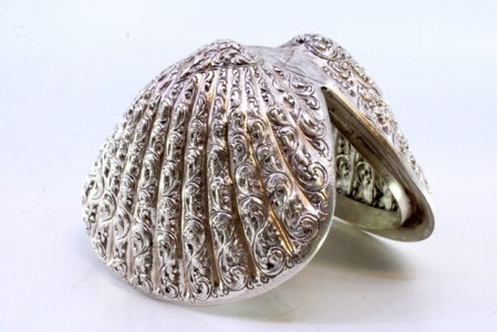 Concha em prata em forma de ameijoa com relevos e dupla tampa basculante.