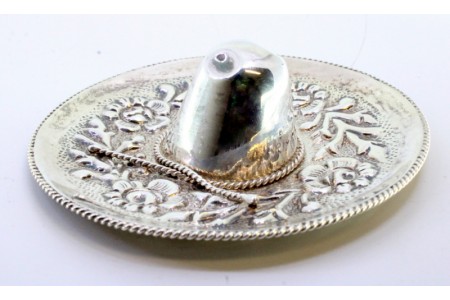 Chapéu mexicano em prata com aplicação e frisos cordeados com motivos florais relevados.