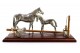 Conjunto de cavalo e potro com sela e balde com esfregona em prata assente em base de madeira envernizada.