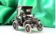 Figura de carro antigo em prata revelada.
