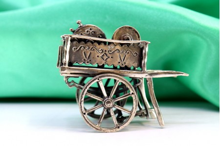 Carrinho de amolador em prata com aplicações, gravados e relevos.