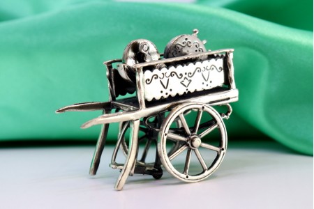 Carrinho de amolador em prata com aplicações, gravados e relevos.