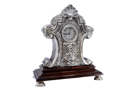 Relógio regulador de mesa em madeira com aplicações em prata e quatro bases circulares de apoio.